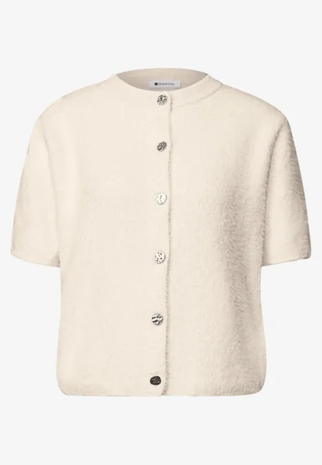 Gilet court crème en tissu teddy, col rond et boutons sur le devant.