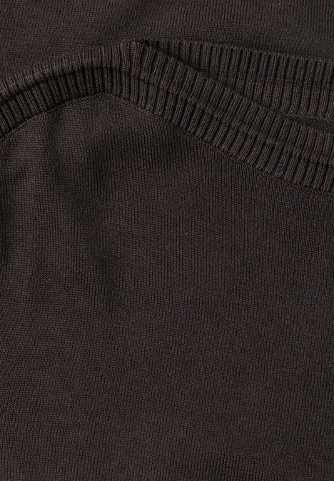 Nahaufnahme eines schwarzen Textilkleidungsstücks mit strukturierter Bundnaht.