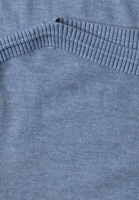 Eenvoudige trui met boothals northern blue mel. Nahaufnahme eines hellblauen Strickpullovers mit geripptem Saum.