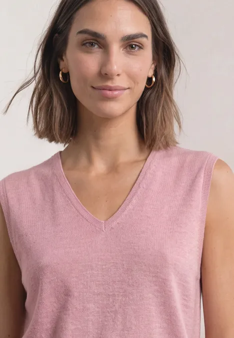 Pullunder mit V-Neck in Unifarbe vintage blush mel. Frau mit schulterlangen braunen Haaren, trägt ärmelloses rosa V-Neck-Top und goldene Creolen.