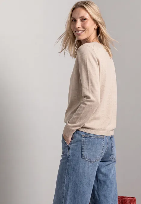 Basic Pullover mit U-Boot-Ausschnitt clay sand mel. Frau mit beigem Pullover und weiten Jeans, sieht lächelnd über die Schulter.