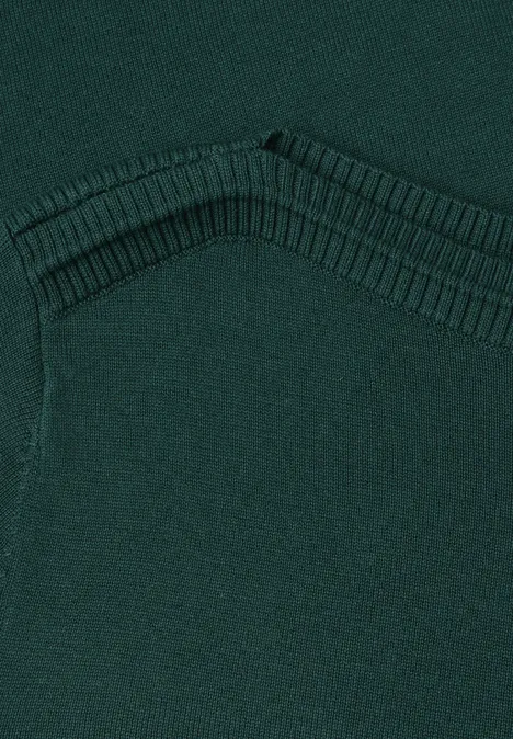 Nahaufnahme eines dunkelgrünen Strickpullovers mit V-förmiger Ziernaht.