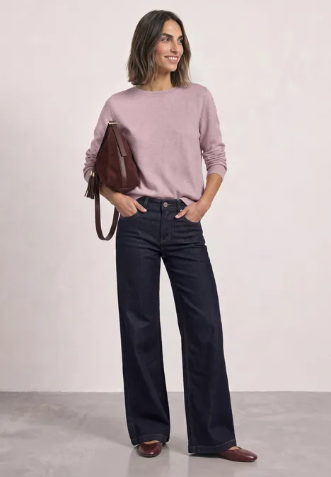 Sweter Basic z dekoltem w łódkę quiet rose mel. Kobieta w różowym swetrze, szerokich dżinsach, brązowych butach i bordowej torebce stoi swobodnie.