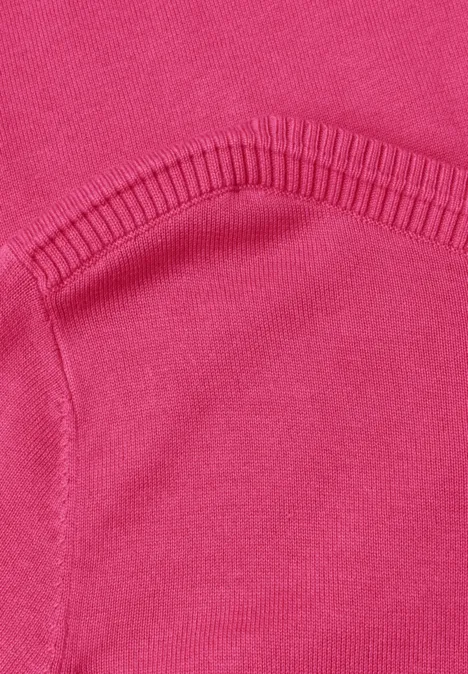 Nahaufnahme eines pinken Sweatshirts mit aufgesetzter Tasche und Rippbündchen.