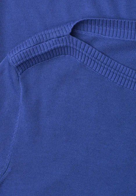 Nahaufnahme eines königsblauen Kleidungsstücks mit Nahtdetail und Eingrifftasche