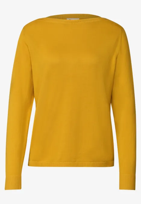 Ein gelber Pullover mit langen Ärmeln.