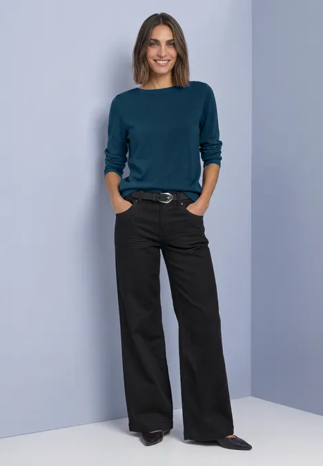 Basic Pullover mit U-Boot-Ausschnitt blue petrol Frau mit dunkelblauem Pullover und schwarzen, weiten Hosen vor hellem Hintergrund