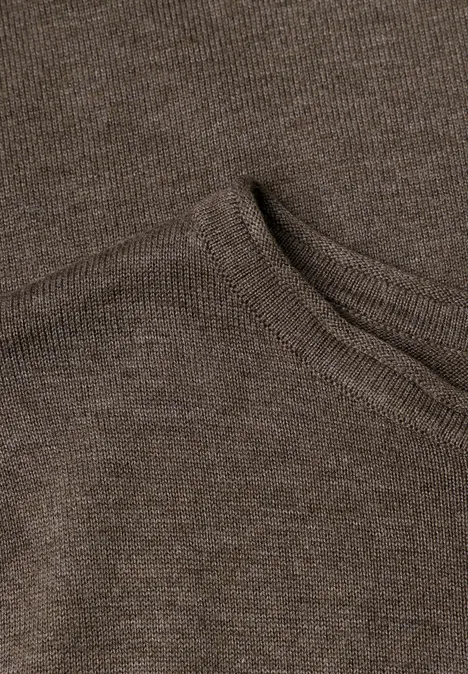 Nahaufnahme eines braunen Strickpullovers mit aufgesetzter Tasche.