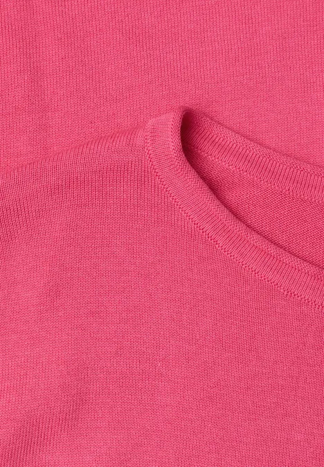 Nahaufnahme eines rosafarbenen T-Shirts mit sichtbarem Rundhalsausschnitt und feiner Stoffstruktur.