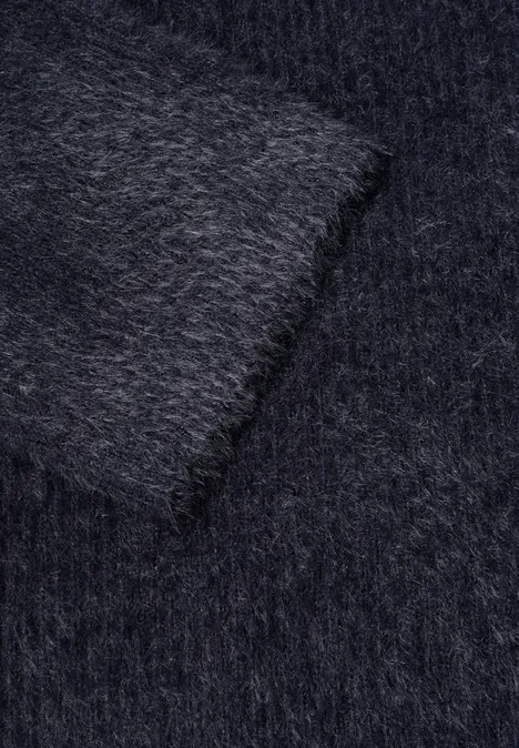 Close-up van een donkergrijze, pluizige stof met een zachte, dichte textuur.