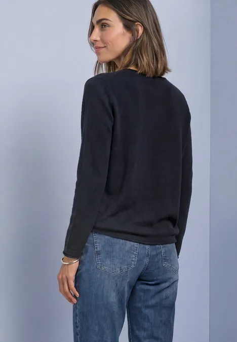 Pullover mit Boat Neck und Rollkanten indigo night Eine Frau in einem schwarzen Pullover und Jeans blickt über die Schulter nach rechts.
