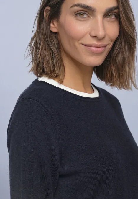 Pullover mit Boat Neck und Rollkanten indigo night Frau mit schulterlangem braunem Haar und leichtem Lächeln, trägt dunkles Oberteil vor hellem Hintergrund.