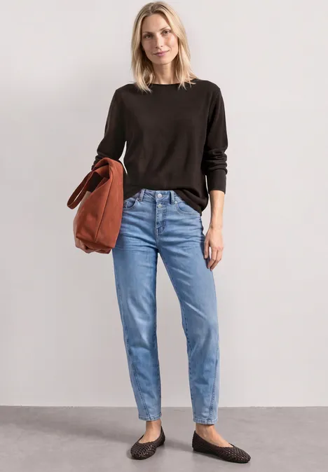 Trui met bootnek en omgeslagen randen black coffee Vrouw in zwarte trui, lichtblauwe jeans en zwarte ballerina's met een roestkleurige tas.