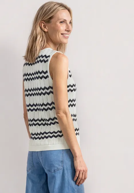 Strick-Top mit Zick-Zack-Muster off white Rückansicht einer Person mit gestrickter Weste und Jeans vor neutralem Hintergrund.