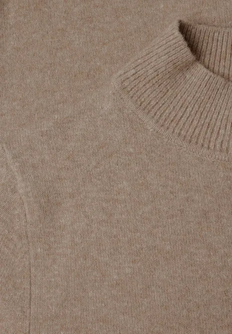 Nahaufnahme eines beigen Strickpullovers mit Rollkragen und feiner Maserung
