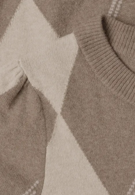 Nahaufnahme eines Strickpullovers mit beigen und hellbraunen Rauten.