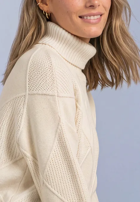 Frau mit halb sichtbarem Gesicht trägt cremefarbenen Strick-Rollkragenpullover.