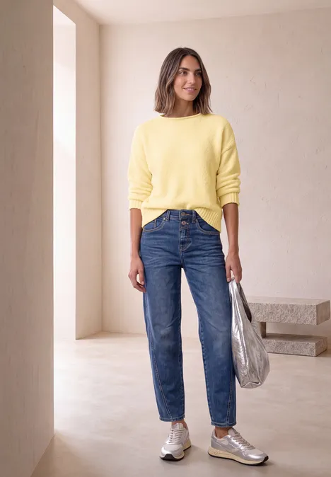Chenille-Pullover mit U-Boot-Ausschnitt sunbeam yellow Frau in minimalistischem Raum trägt gelben Pullover, blaue Jeans, silberne Sneaker und hält eine silberne Tasche.