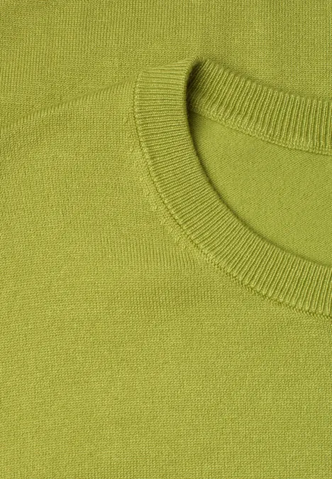 Nahaufnahme eines hellgrünen Pullovers mit Rundhalsausschnitt und feiner Strickstruktur.