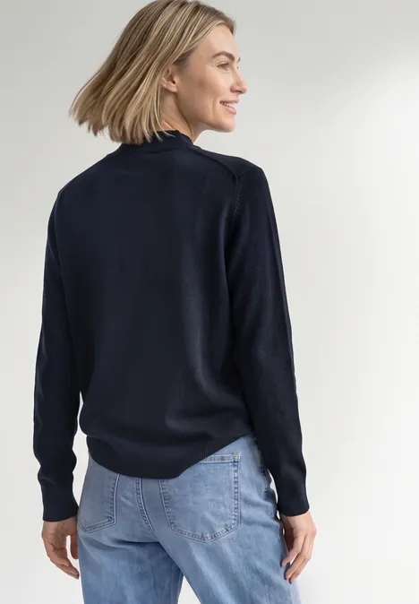 Basic sweter z golfem darkest blue Kobieta od tyłu w granatowym swetrze i jasnych dżinsach, spogląda bokiem z lekkim uśmiechem.