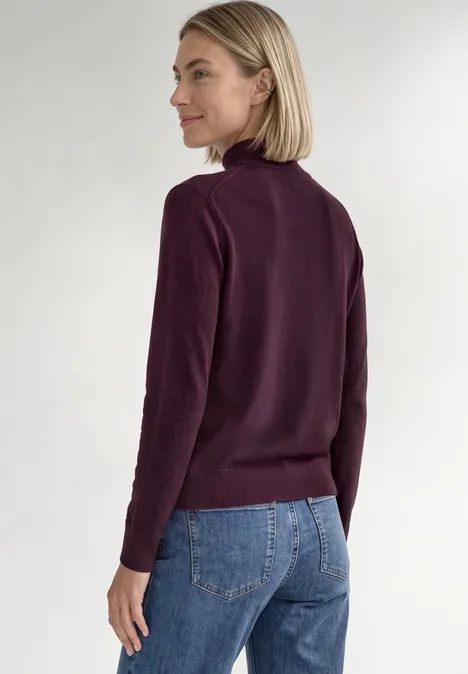 Basic sweter z golfem berry maroon Kobieta bokiem w bordowym golfie i dżinsach