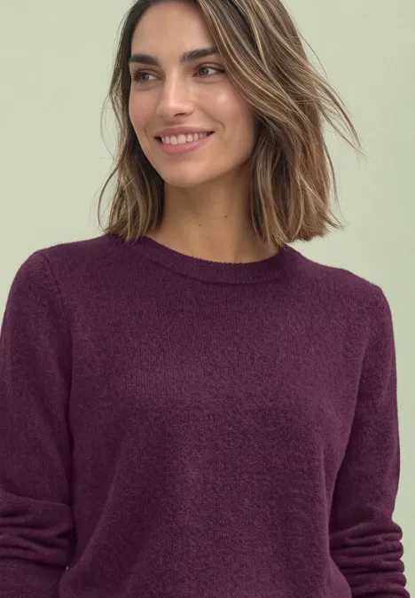 Langarm Pullover mit Rundhals und Raffung berry maroon mel. Die lächelnde Frau trägt einen dunkelvioletten Pullover und hat schulterlanges braunes Haar.