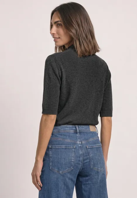 Kurzarm Pullover mit Turtle Neck armor grey mel. Frau mit schulterlangem Haar in dunkelgrauem Oberteil und blauen Jeans, Rückansicht.