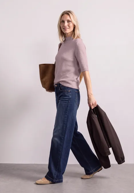 Kurzarm Pullover mit Turtle Neck quiet rose mel. Frau in hellem Pullover und weitem Jeans, mit Tasche über der Schulter und Jacke am Arm.