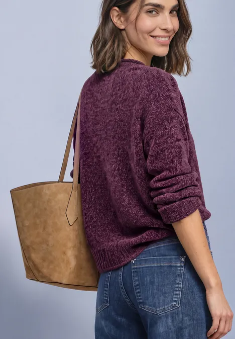Chenille-Pullover mit U-Boot-Ausschnitt berry maroon Frau in lila Pullover und Jeans trägt eine beige Tasche und schaut lächelnd über die Schulter.