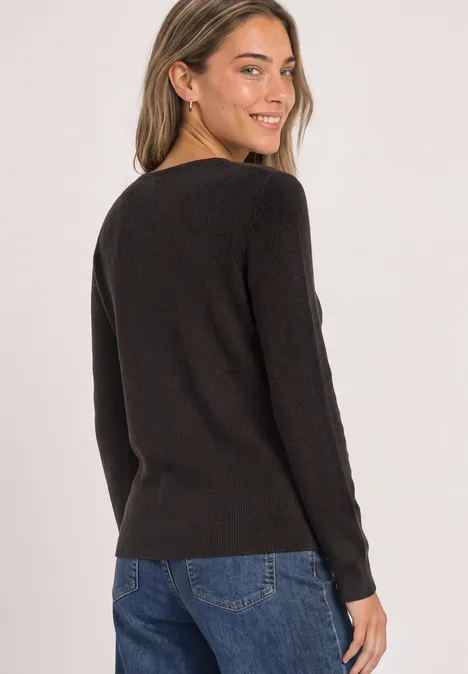 Langarm Pullover mit V-Ausschnitt black coffee Frau in schwarzem Pullover und Jeans blickt über die Schulter, lächelnd vor weißem Hintergrund.