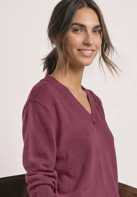 Langarm Pullover mit V-Ausschnitt dark clouded blush Frau mit locker gebundenem Haar trägt burgunderfarbenen V-Neck-Pullover und lächelt.