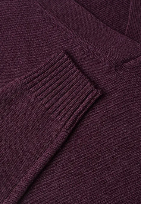 Nahaufnahme eines dunkelroten Strickpullovers mit V-Ausschnitt.