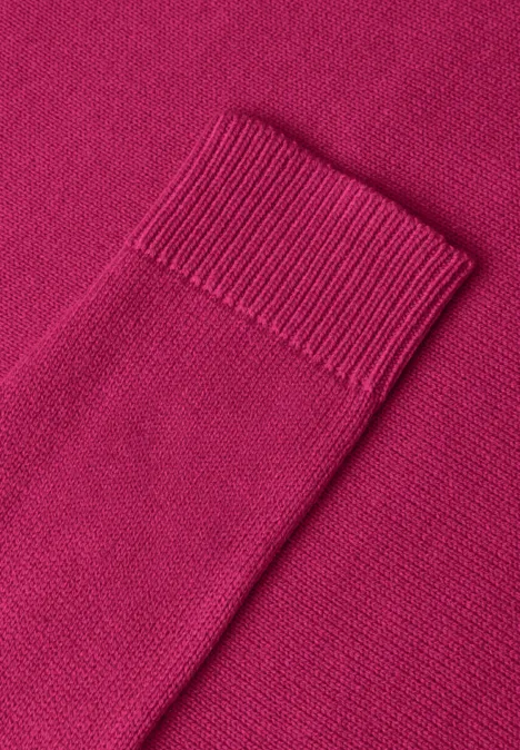Nahaufnahme eines pinken Strickpullovers auf passendem Hintergrund