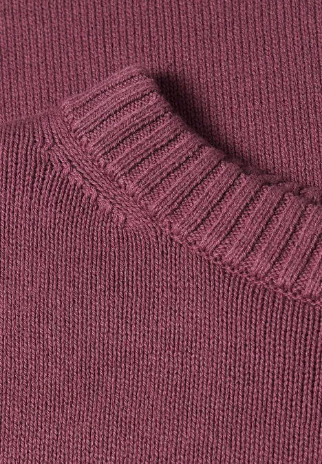 Nahaufnahme eines burgunderfarbenen Strickpullover-Kragens.