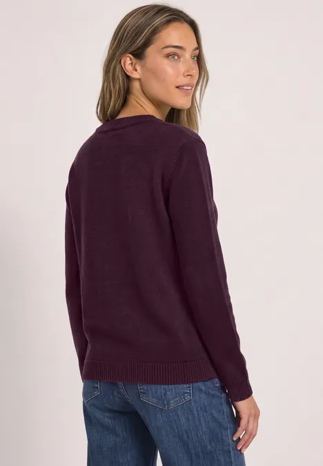 Langarm Pullover mit Boat Neck berry maroon Frau in lila Pullover und Jeans, schaut über die Schulter vor hellem Hintergrund.