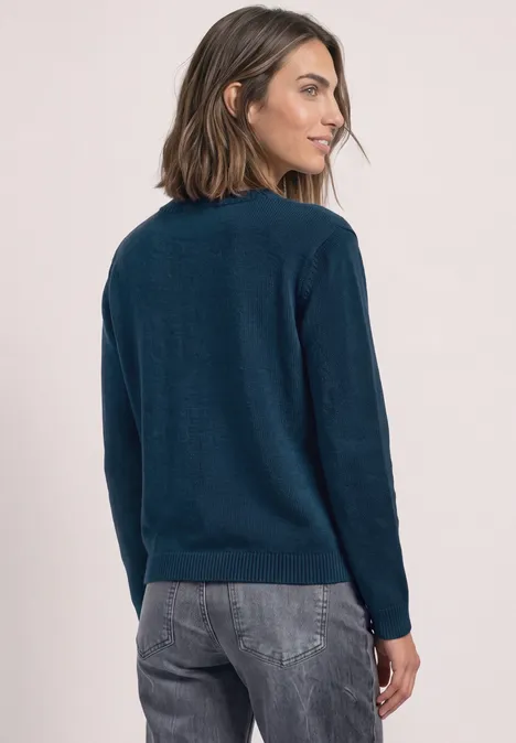 Langarm Pullover mit Boat Neck blue petrol Frau mit dunkelblauem Pullover und Jeans, leicht zur Seite gedreht, Rücken zur Kamera.