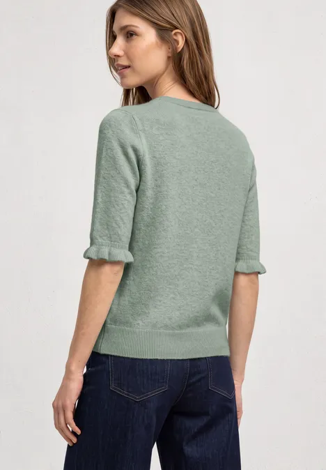 Kurzarm Pullover mit Rundhals und Rüschen eucalyptus green mel. Frau in olivgrünem Kurzpullover mit halblangen Ärmeln und blauer Jeans, seitlich stehend.