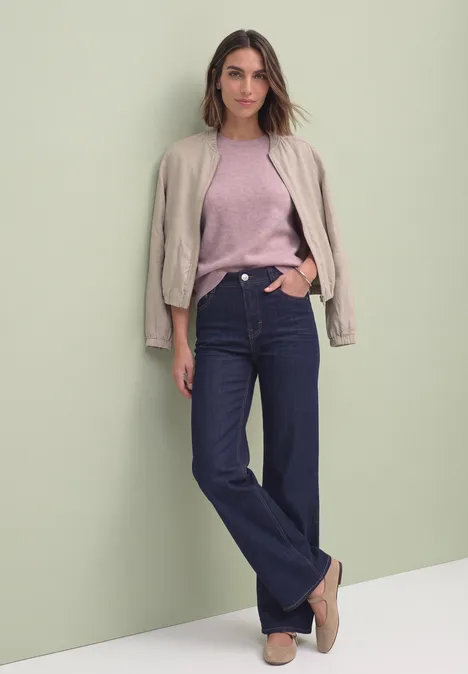Kurzarm Pullover mit Rundhals und Rüschen quiet rose mel. Eine Frau trägt eine rosa Bluse, blaue Jeans und eine Jacke leger über den Schultern.