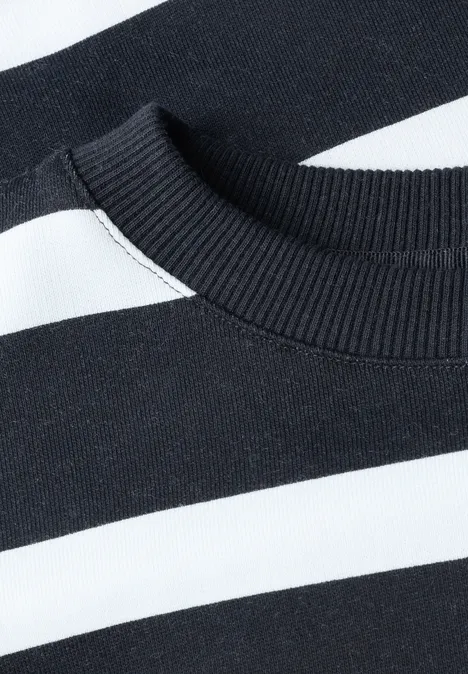 Detailfoto van de halslijn van een zwart-wit gestreepte trui met ronde hals.