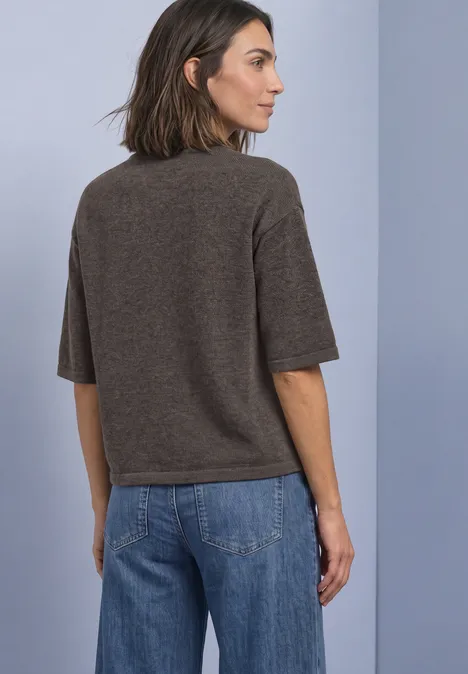 Pull à manches 3/4 et col rond black coffee mel. Frau von hinten in braunem Kurzarm-Pullover und blauen Jeans vor hellgrauem Hintergrund.
