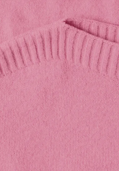 Close-up van een roze gebreide trui met geribbelde kraag en een zak.