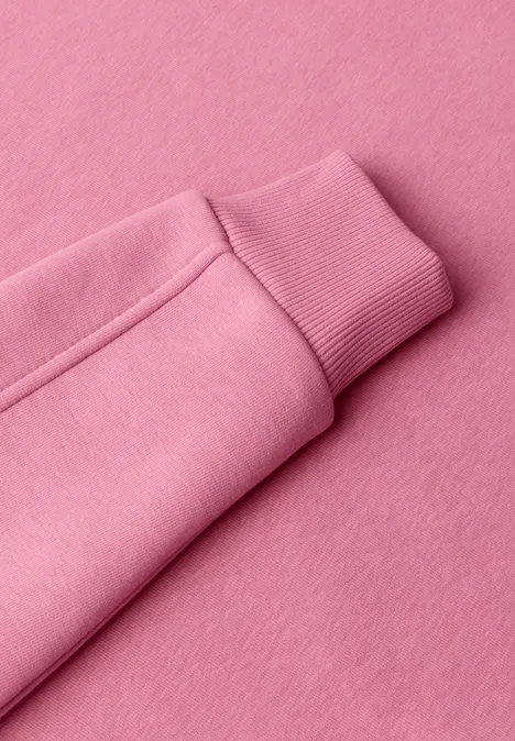 Nahaufnahme eines rosa Sweatshirtärmels mit Bündchen.
