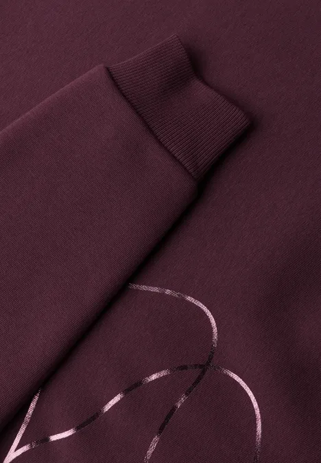 Sweatshirt met Loose Fit-pasvorm en folieprint rustic rouge Nahaufnahme eines weinroten Sweatshirts mit glänzendem Linien-Print auf dem Ärmel.