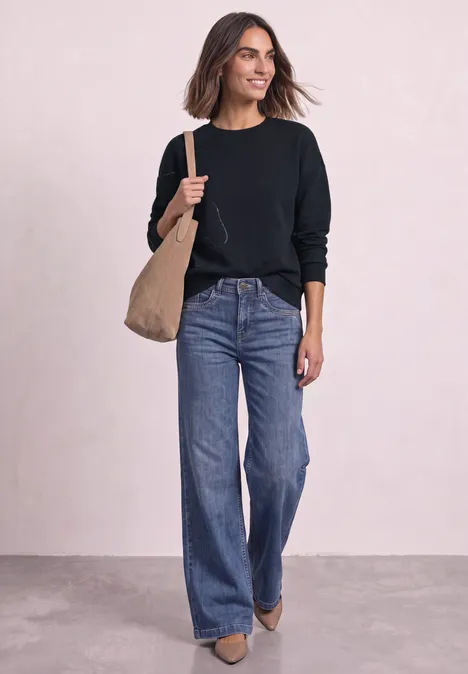 Sweatshirt met Loose Fit-pasvorm en folieprint indigo night Frau in schwarzem Pullover und weiten Jeans trägt große beige Tasche