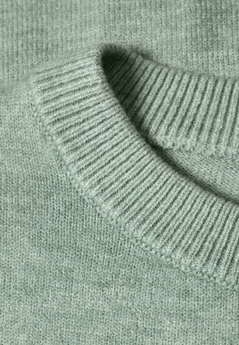 Nahaufnahme eines mintgrünen Strickpullovers mit geripptem Rundhalsausschnitt.