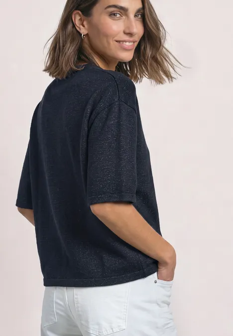 3/4-Arm Pullover mit Rundhals darkest blue mel. Frau im Profil trägt dunkelblaue Kurzarmbluse und weiße Hose, Hände in den Taschen