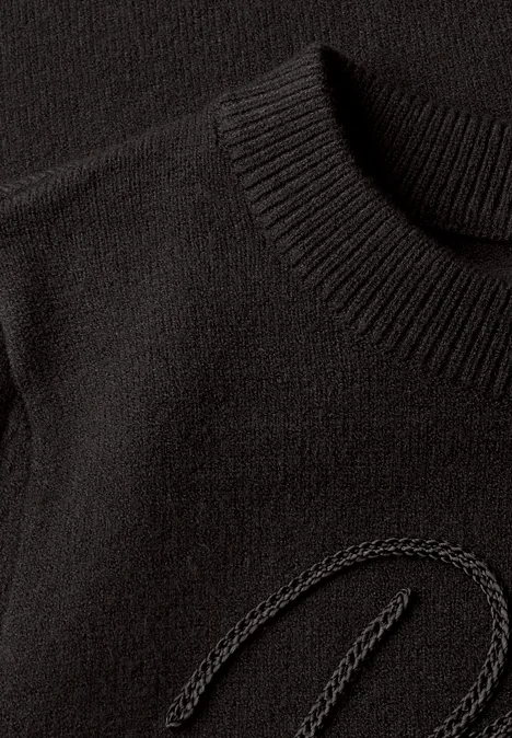 Pullover mit Emboidery Wording black coffee Nahaufnahme eines schwarzen Strickpullovers mit dezentem, eingearbeitetem Logo-Detail.