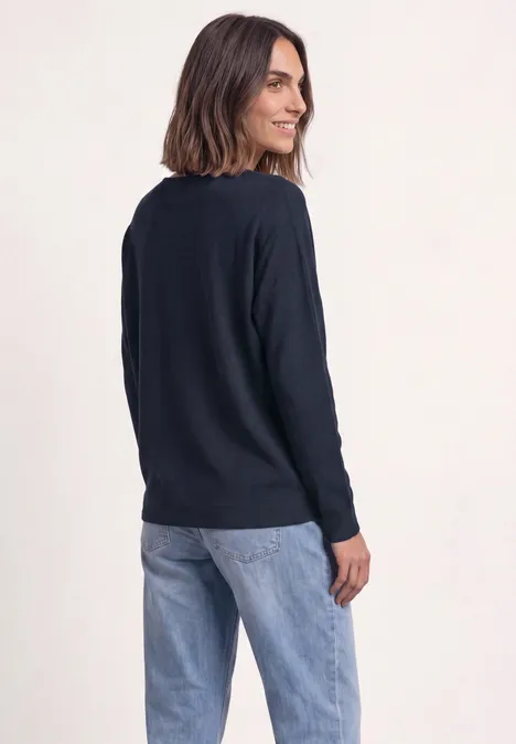 Dolman Pullover mit Boat Neck darkest blue Frau in dunkelblauem Pullover und Jeans, seitlich stehend, lächelnd über die Schulter blickend.