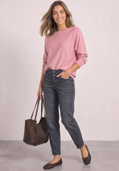 Dolman Pullover mit Boat Neck vintage blush mel. Frau in rosa Pullover und dunklen Jeans mit brauner Tasche und schwarzen Ballerinas vor hellem Hintergrund.