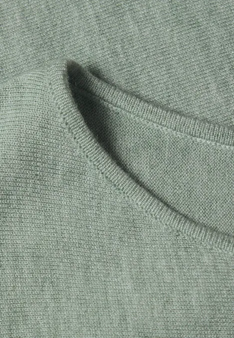 Dolman-trui met boothals eucalyptus green mel. Close-up van de ronde hals van een groen-grijs T-shirt van zachte stof.
